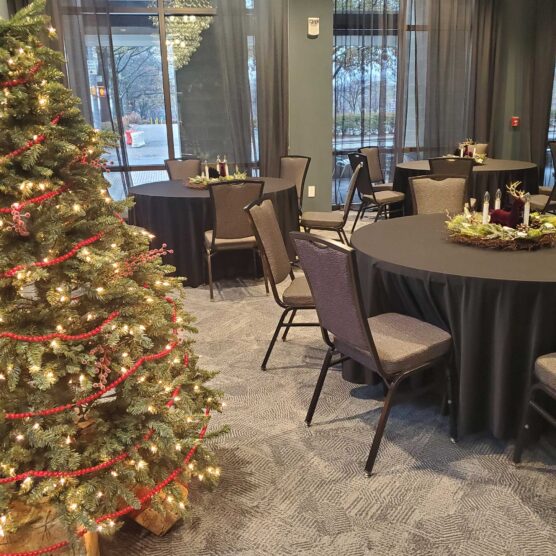 christmas tree on the left and round dining tables with festive display in the background