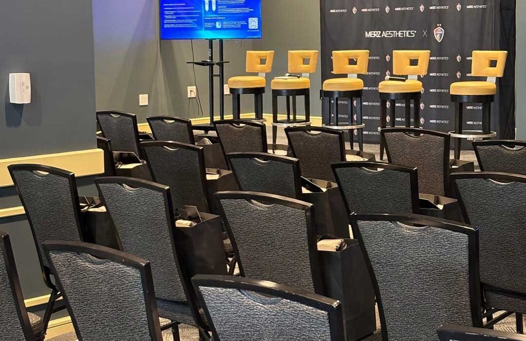 rows of seats facing presentation area with tv and stools