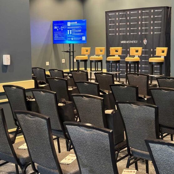 rows of seats facing presentation area with tv and stools