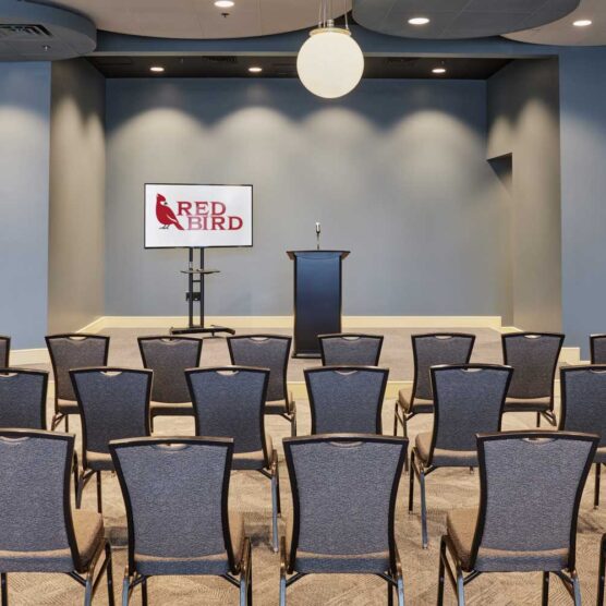 rows of chairs facing tv and podium