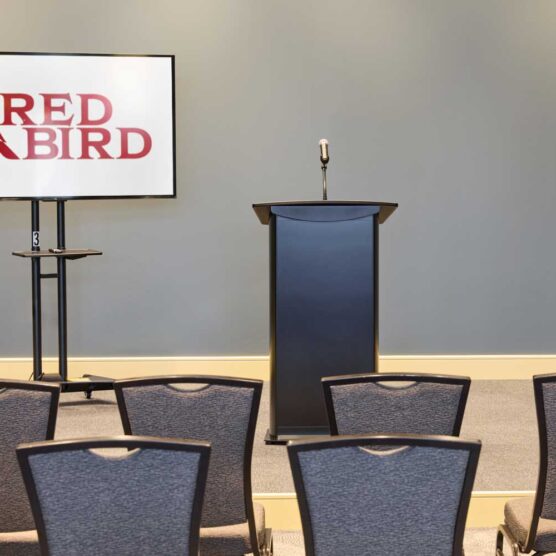 rows of chairs facing tv and podium