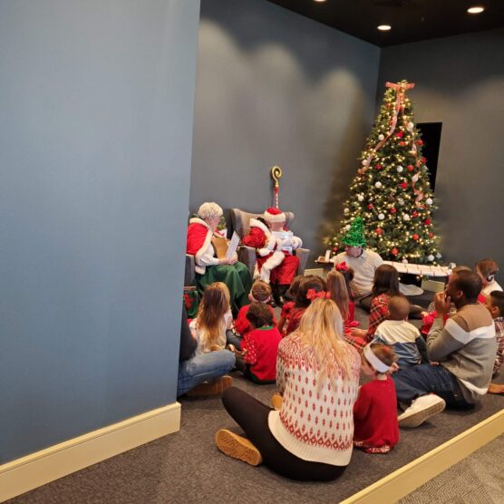 people sitting on the floor in front of Santa and his wife