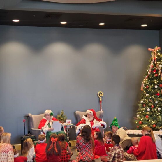 people sitting on the floor in front of Santa and his wife