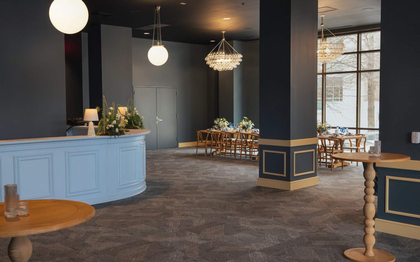 a large room, mainly empty with a long table and chairs along a large window