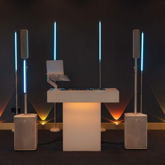 dj podium with laptop and two tall speakers on the left and right