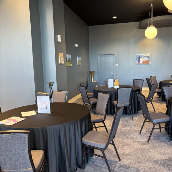 round tables and chairs set up in a large room