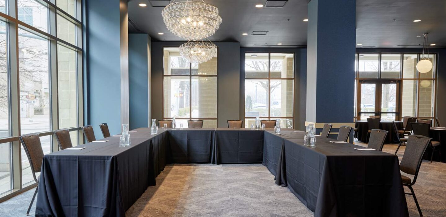 tables set in a u-shape for a conference meeting