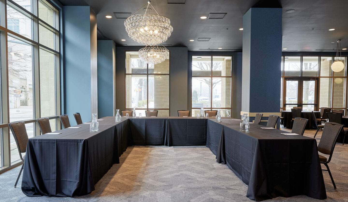 tables set in a u-shape for a conference meeting